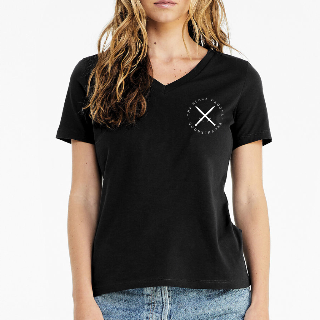 the front of a black v-neck shirt with an emblem on the top left shoulder. It's a circle with crossed black daggers and the words "Black Dagger Brotherhood" encircling it.