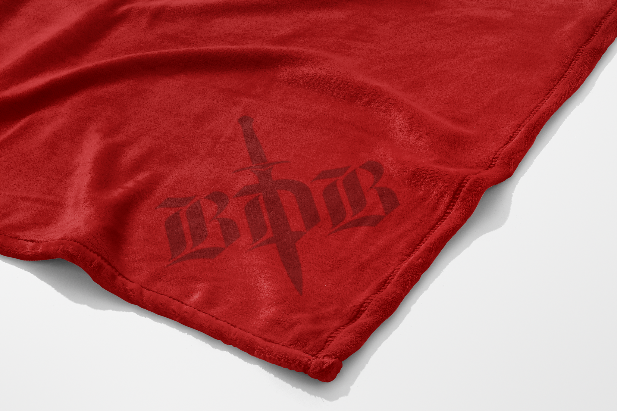 a corner of a red fleece blanket with BDB etched in the corner