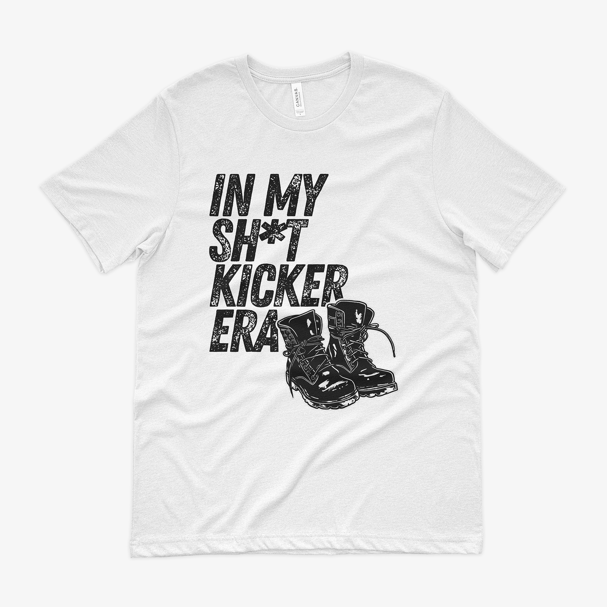 a white shirt with the words "in my sh*t kicker era" in bold black letters. A pair of combat boots are tucked in the corner.