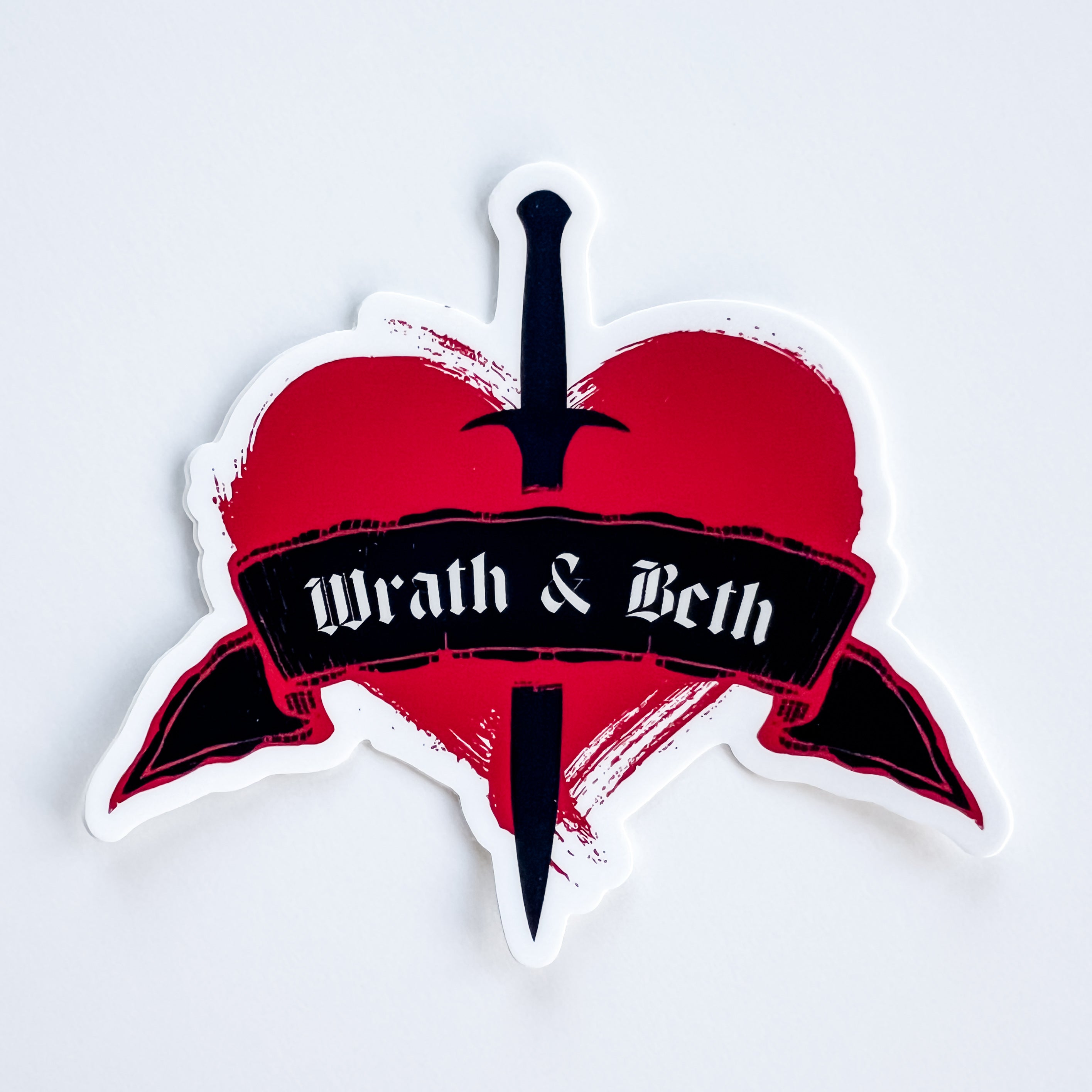 Sticker with a red heart, black dagger, and 'Wrath & Beth' text on a white background