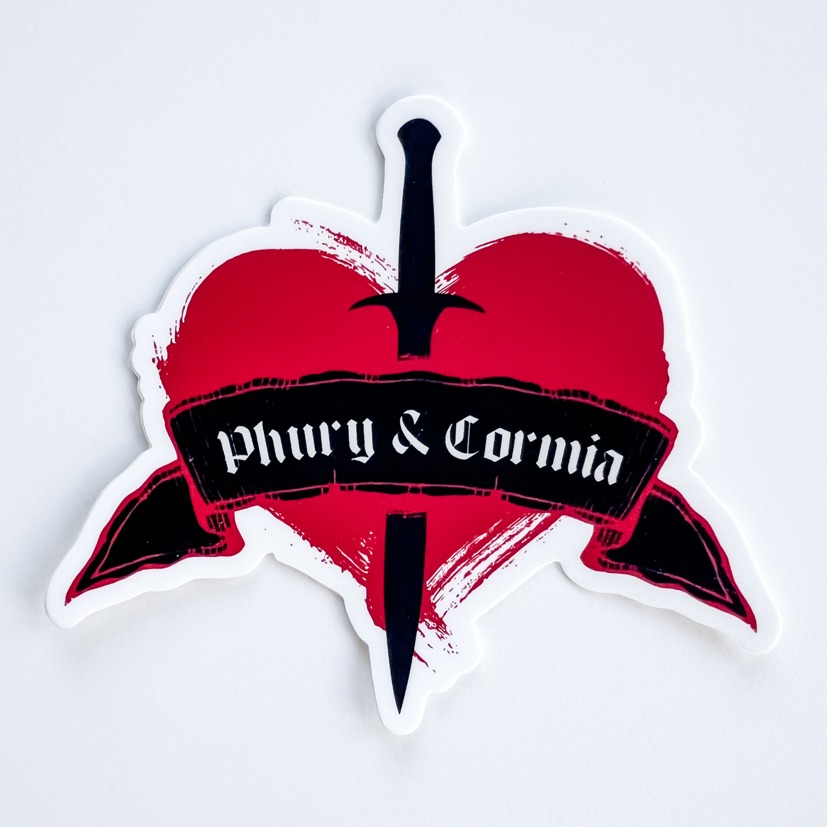 Heart-shaped design with a dagger and 'Phury & Cormia' text on a white background