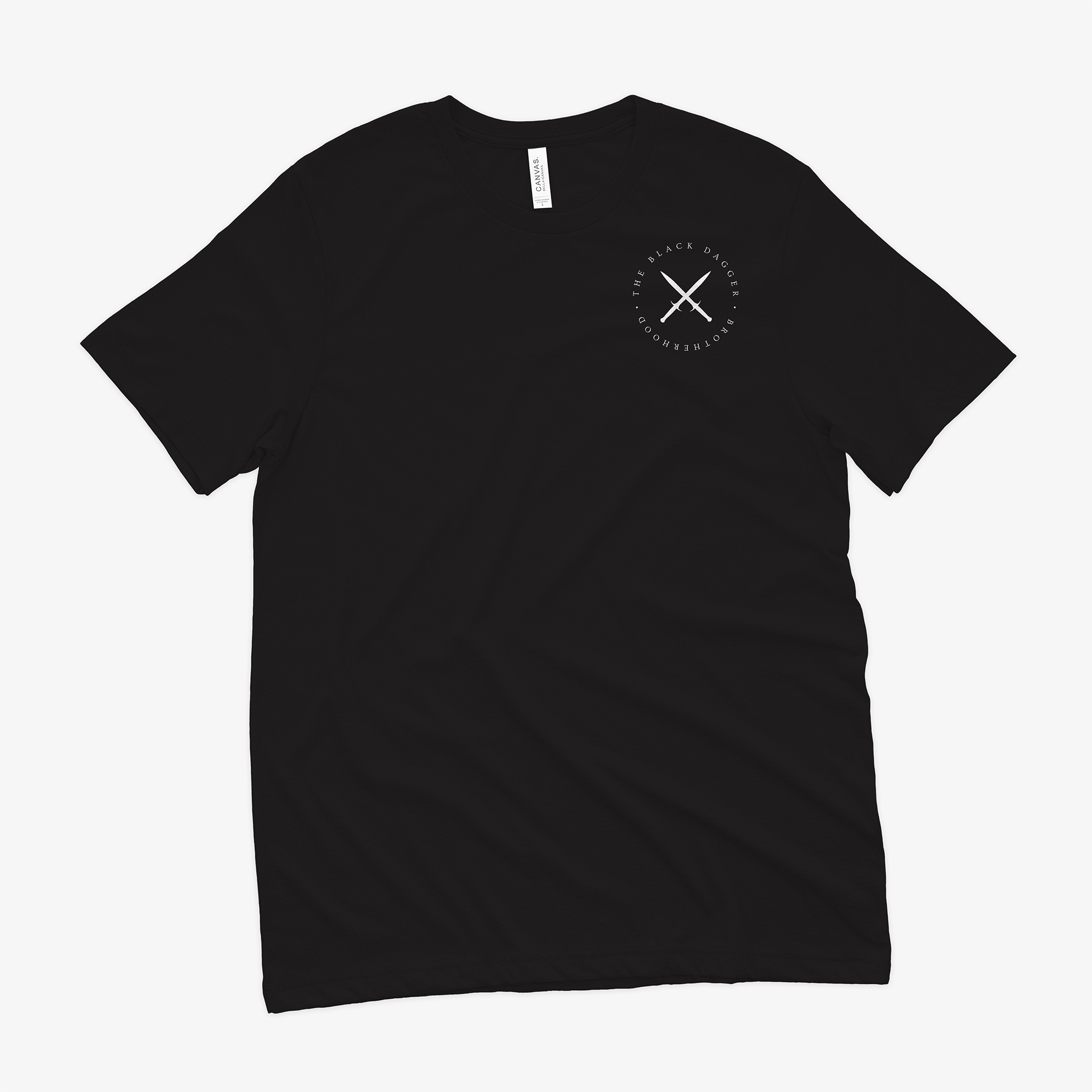 the front of a black shirt with an emblem on the top left shoulder. It's a circle with crossed black daggers and the words "Black Dagger Brotherhood" encircling it.