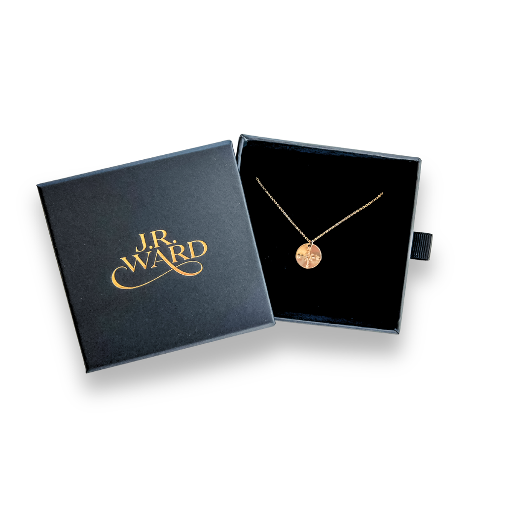 Gold necklace in a black box with 'J.R. Ward' branding on a white background