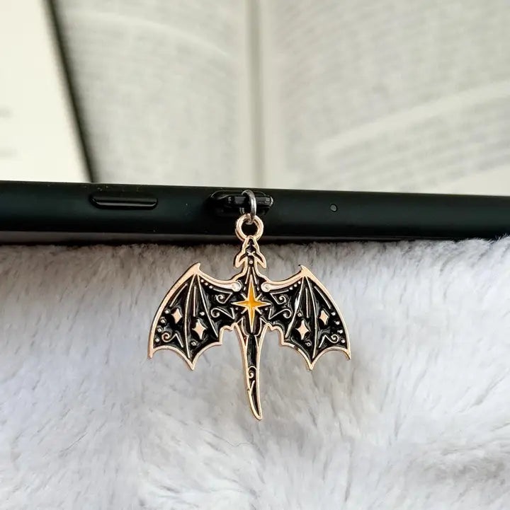 black dragon with gold accents pendant on a black phone case with a white textured background