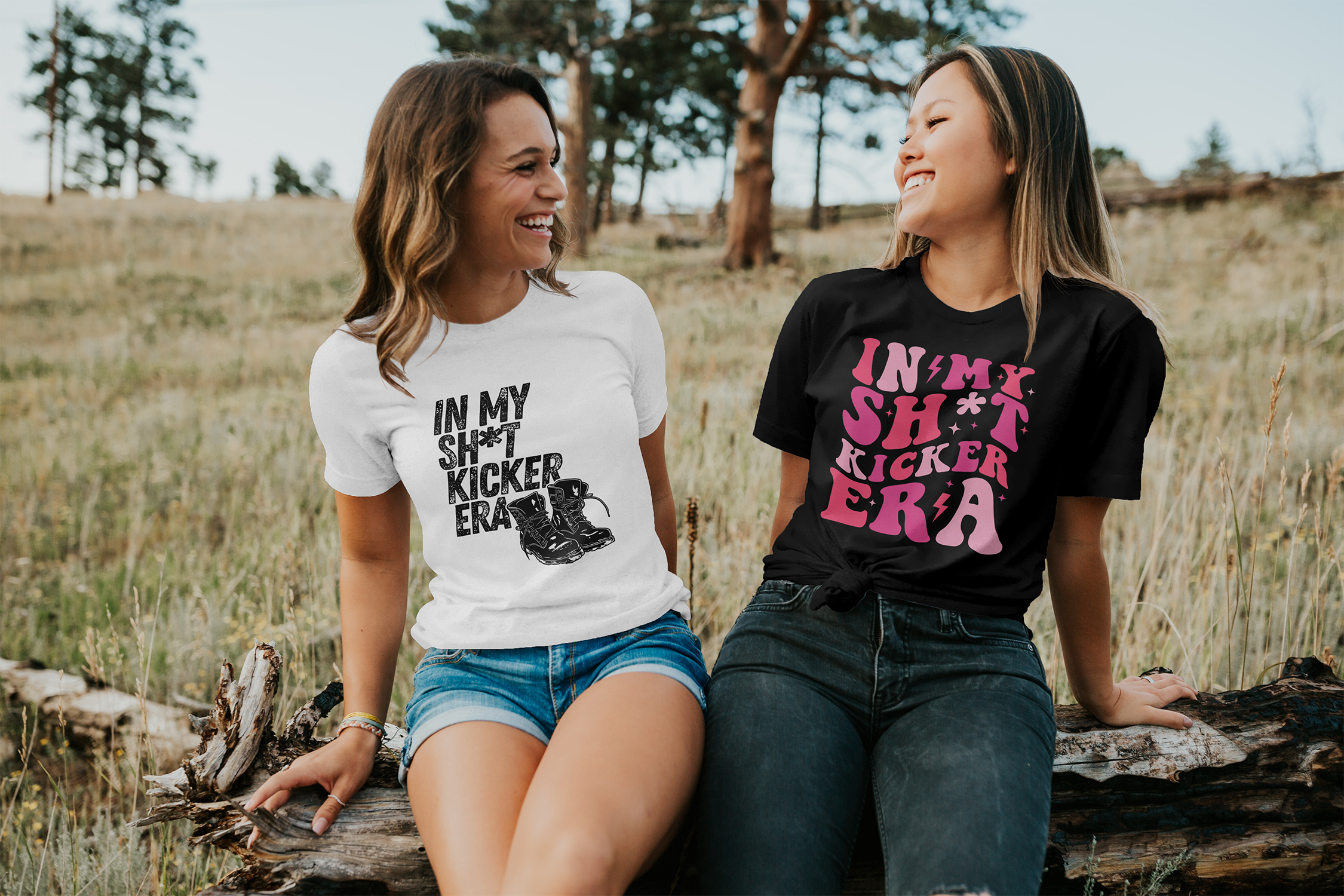 two friends are smiling at each other. The one on the left is wearing the grunge sh*t kicker shirt. The girl on the right is wearing the retro sh*t kicker shirt.